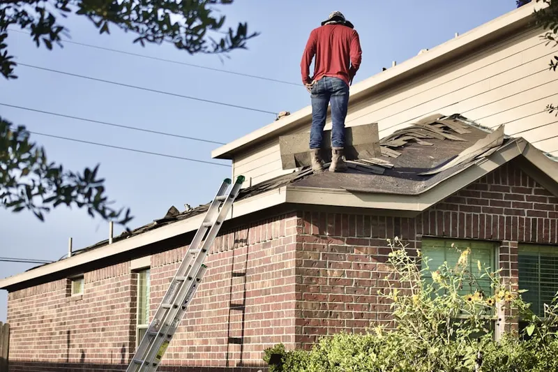 Professional roofer working on a residential roof in Goldsmith